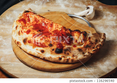 Rustic Calzone on a Wooden Board 116296540