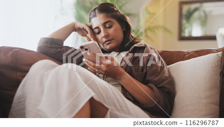 Living room, phone and reading in home, girl and thinking in morning, digital and online on couch. House, social media and lounge with web, calm and texting in apartment, streaming or subscription 116296787