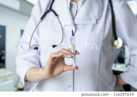 Doctor holding a syringe of medicine . Doctor holding a syringe of medicine . 116297014