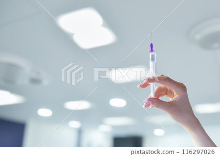 In the hand of the doctor there is a syringe with a vaccine . In the hand of the doctor there is a syringe with a vaccine . 116297026