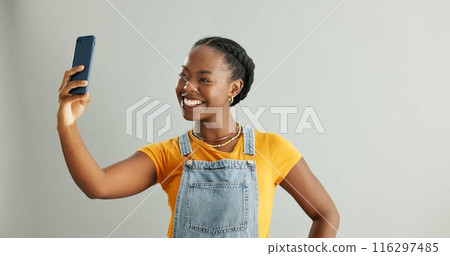 Woman, selfie and happy in studio with smartphone, photography and social media update with tech communication. Influencer, mobile app and confident for profile picture, smiling and blog post 116297485