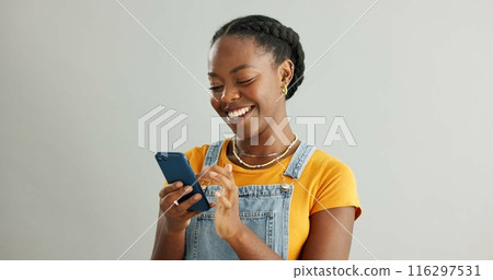 Woman, happy and typing in studio on smartphone, browsing and reading text message on mobile app on background. Communication, social media update and scrolling with internet, website and email 116297531