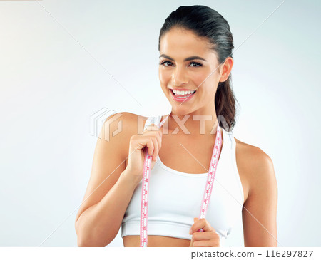 Woman, portrait and smile with measuring tape for diet progress, fitness or wellness on white background. Happy, workout and girl with nutrition, health results or confidence to lose weight in studio Woman, portrait and smile with measuring tape for diet progress, fitness or wellness on white background. Happy, workout and girl with nutrition, health results or confidence to lose weight in studio 116297827