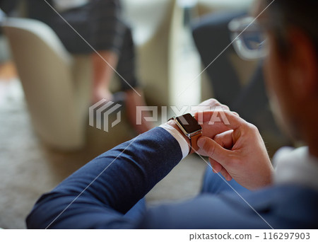 Hands, corporate and man with smart watch, time management and professional in modern office. Clock closeup, employee in suit or consultant with deadline, appointment and schedule with network or app 116297903