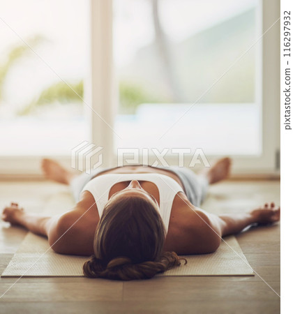 Woman, home and yoga savasana for relax, wellness or zen for healthy body. Female person, house and calm peace with corpse pose for natural breathing on floor, balance exercise by window for mindset 116297932