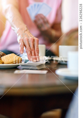 Elderly woman, table and hand with cards in retirement home for activity, hobby and fun on weekend. Games, senior person and relax with snack in living room for problem solving, strategy and contest Elderly woman, table and hand with cards in retirement home for activity, hobby and fun on weekend. Games, senior person and relax with snack in living room for problem solving, strategy and contest 116298228