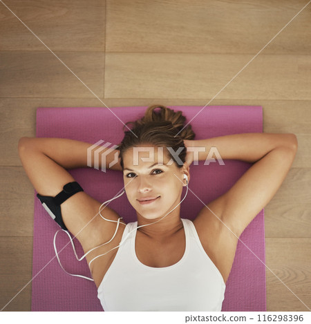 Portrait, mat and woman with earphones in home relaxed for listening to podcast, wellness and yoga. Peaceful, female person and music on floor for pilates training, self care and workout from above Portrait, mat and woman with earphones in home relaxed for listening to podcast, wellness and yoga. Peaceful, female person and music on floor for pilates training, self care and workout from above 116298396