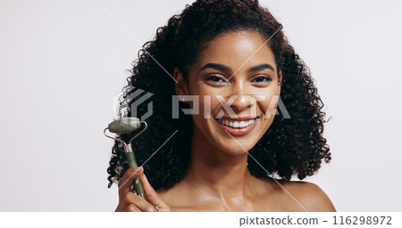 Face roller, smile and woman with cosmetics, shine and makeup on grey studio background. Portrait, person and model with tool, wellness and massage with skincare, dermatology and grooming routine 116298972