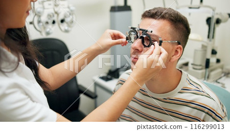 Optometrist, patient and assessment in clinic for eye exam, optometry and vision with phoropter. Specialist, man and testing machine in hospital for wellness, healthcare or ophthalmology for glaucoma Optometrist, patient and assessment in clinic for eye exam, optometry and vision with phoropter. Specialist, man and testing machine in hospital for wellness, healthcare or ophthalmology for glaucoma 116299013
