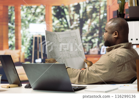 Professional entrepreneur evaluating building layout on blueprints, hunting property for leasing to relocate the office space. Investing in real estate for business development. 116299136