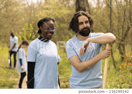 Portrait of diverse team of volunteers restoring forest habitat by planting seeds and growing trees, recycle garbage. Activists protecting wildlife and ecosystems, doing voluntary work. 116299142
