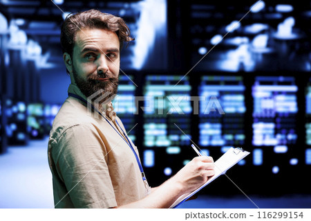 Worker using clipboard to take note of supercomputers doing data backups and providing centralized storage. Repairman offering technical support in server room ensuring operational continuity Worker using clipboard to take note of supercomputers doing data backups and providing centralized storage. Repairman offering technical support in server room ensuring operational continuity 116299154