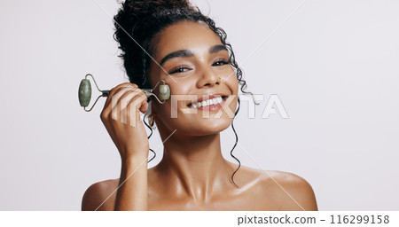 Face roller, smile and woman with cosmetics, skincare and makeup on grey studio background. Portrait, person and model with tool, wellness and treatment with beauty, dermatology and grooming routine Face roller, smile and woman with cosmetics, skincare and makeup on grey studio background. Portrait, person and model with tool, wellness and treatment with beauty, dermatology and grooming routine 116299158