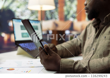 Businessman doing research to calculate profit and expenses at home, working on accounting balance for financial planning. Entrepreneur providing an insurance plan for expansion. Businessman doing research to calculate profit and expenses at home, working on accounting balance for financial planning. Entrepreneur providing an insurance plan for expansion. 116299243