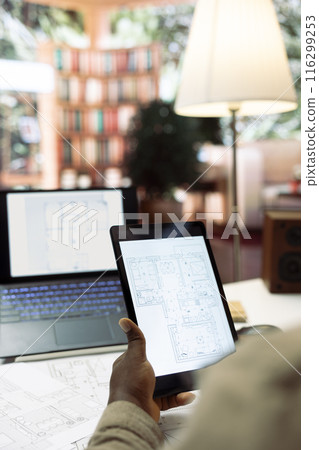 Entrepreneur conducting research and evaluating office spaces layouts on architectural blueprints, focusing on real estate investment strategy for business development. Close up. Entrepreneur conducting research and evaluating office spaces layouts on architectural blueprints, focusing on real estate investment strategy for business development. Close up. 116299253