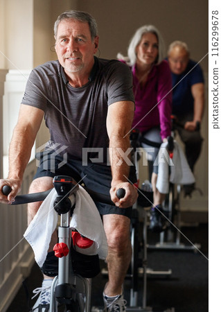 Fitness, spinning class and senior man in gym for cycling, exercise and training with physical activity. Workout club, team and people on bicycle for health, wellness and endurance with cardio 116299678