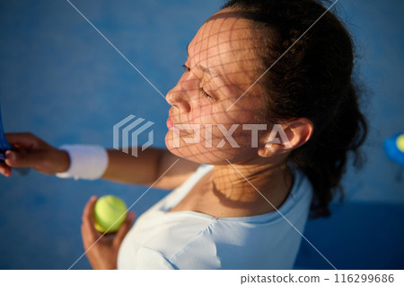 Woman preparing to serve tennis ball on sunny day Woman preparing to serve tennis ball on sunny day 116299686