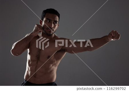 Man, boxer and punching in studio for fitness for mma sport, fighter and background or training for challenge or competition fight. Strong, power and exercise for strength, combat workout and health Man, boxer and punching in studio for fitness for mma sport, fighter and background or training for challenge or competition fight. Strong, power and exercise for strength, combat workout and health 116299702