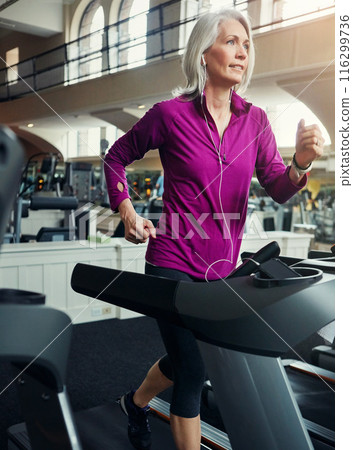 Senior woman, running on treadmill and training with fitness in gym, cardio and breathing for health and wellness. Person, female runner and exercise equipment, mature and workout by speed machine 116299736