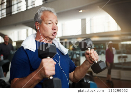 Mature man, weightlifting and exercise with dumbbells for fitness, workout or indoor training at gym. Male person with earphones for arm strength, muscle gain or listening to music at health club 116299962