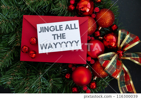 Greeting card with JINGLE ALL THE WAY text on handmade Christmas wreath. Festive mood new year celebration. Postcard decoration decor Greeting card with JINGLE ALL THE WAY text on handmade Christmas wreath. Festive mood new year celebration. Postcard decoration decor 116300039