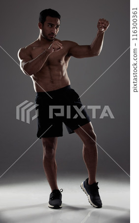 Man, boxer and punch in studio for fitness for mma sport, fighter and background or training for challenge or competition fight. Strong, power and exercise for strength, combat workout and health Man, boxer and punch in studio for fitness for mma sport, fighter and background or training for challenge or competition fight. Strong, power and exercise for strength, combat workout and health 116300361