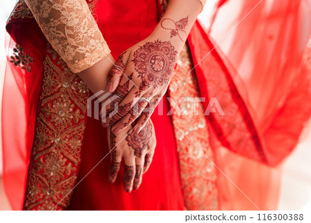 Indian bride, hands and mehendi for wedding, celebration and love for marriage. Woman, henna and culture with traditional temporary tattoo, sari and hindu bridal jewelry with bangles and red veil 116300388