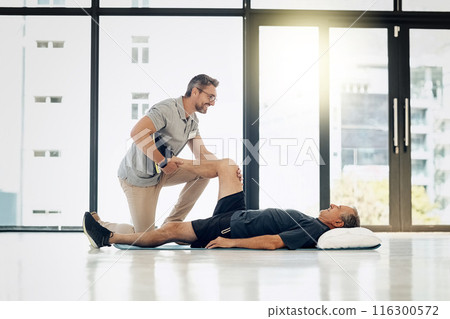 Clinic, physiotherapist and old man on floor with massage, stretching and help in senior rehabilitation. Physio, therapist and elderly patient for mobility training, exercise or support in retirement 116300572