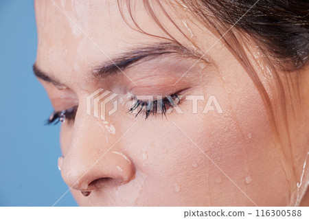 Woman, cleanse and shower for facial in studio, washing and grooming for skincare on blue background. Female person, water and liquid for cosmetics or treatment and hydration for skin, beauty and wet 116300588