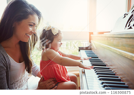 Mom, toddler and happy for learning by piano with help, care or bonding for love in family home. Girl, mother and daughter by keyboard for music, teaching or playing for development with art in house 116300875