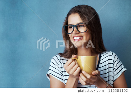 Woman, student and coffee in studio with thinking, drink and glasses on blue background. Smile, caffeine or energy or mockup for learner person, hands and matcha or green tea for hydration and relax 116301192