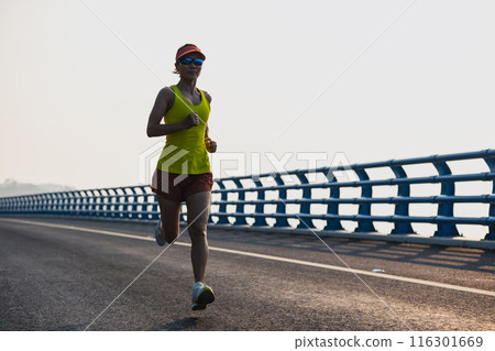 Fitness woman runner running on seaside bridge Fitness woman runner running on seaside bridge 116301669