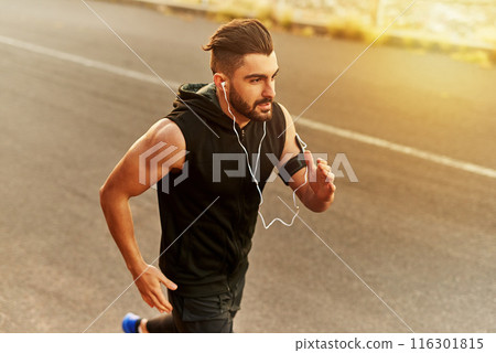 Sunset, running and man with earphones in countryside for streaming music and exercise on road. Mountain, athlete and bodybuilder in nature for wellness, workout and training with podcast in summer Sunset, running and man with earphones in countryside for streaming music and exercise on road. Mountain, athlete and bodybuilder in nature for wellness, workout and training with podcast in summer 116301815