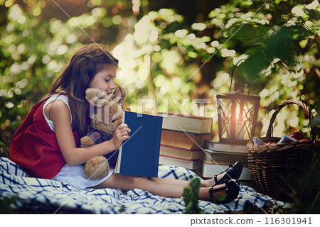 Picnic, girl and child with book, reading and smile for red cloak, nature and forest for fun and relax. Woods, outdoor and kid with teddy bear, basket and blanket in park, trees and happy youth Picnic, girl and child with book, reading and smile for red cloak, nature and forest for fun and relax. Woods, outdoor and kid with teddy bear, basket and blanket in park, trees and happy youth 116301941