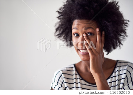 Portrait, African woman and peeking with hand over eye in studio with nervous emoji on mock up space. Female person, gen z and cover face or hide for embarrassed with fear by white background 116302050
