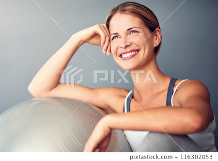 Woman, exercise ball and training for health, wellness and fitness with smile for motivation. Gym, performance and athlete with wall background for workout planning, weight loss support and pilates 116302053