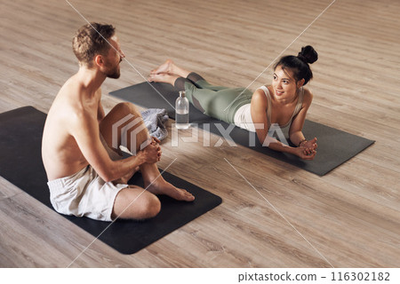 Friends, break and speaking in yoga class on mat, relax and communication in studio for exercise. People, conversation and floor for fitness or meditation, pilates and training together for support Friends, break and speaking in yoga class on mat, relax and communication in studio for exercise. People, conversation and floor for fitness or meditation, pilates and training together for support 116302182