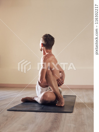 Man, twist and flexible stretching in yoga on floor with back, mockup or exercise for balance in class. Yogi, person or pilates on mat in fitness studio with workout, zen or wellness for healthy body 116302217