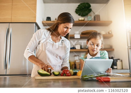Woman, child and cooking with tablet, online for recipe or ingredients on kitchen counter for dinner. Family, healthy and food or meal prep for nutrition, together or bonding for clean eating in home 116302520