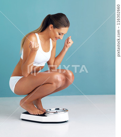 Woman, scale and celebration for weight loss, healthy person and nutrition on blue studio background. Girl, wellness and excited for diet, mockup space and winner with victory and body positivity Woman, scale and celebration for weight loss, healthy person and nutrition on blue studio background. Girl, wellness and excited for diet, mockup space and winner with victory and body positivity 116302660