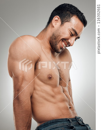 Man, thinking and confident in studio with abs or muscles, shirtless and grey background with model bodybuilder. Jeans, strong chest and Asian male person on backdrop, happy and six pack results 116302681