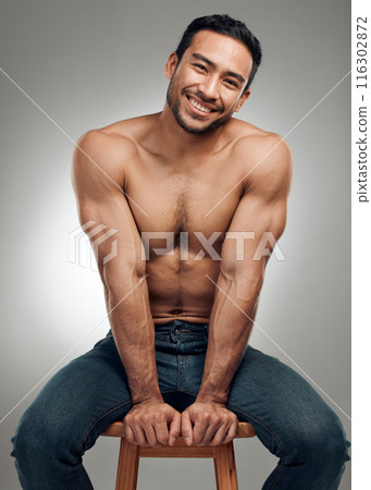 Man, chair and topless in studio portrait, wellness and strong abs muscle on gray background. Male person, denim jeans and shirtless for health, bodybuilder and proud of body or workout results 116302872