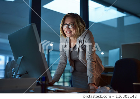 Woman, employee and smile on computer in office for internet, online and research for ideas. Female person, happy and portrait in confidence for career opportunity, growth and standing as hr at night 116303148