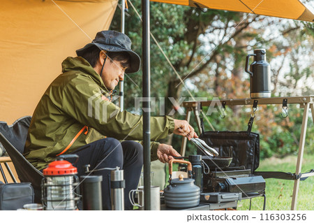 男性露營者在露營地烹飪露營食物 男性露營者在露營地烹飪露營食物 116303256