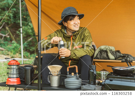 男性露營者在營地使用咖啡研磨機研磨豆子 男性露營者在營地使用咖啡研磨機研磨豆子 116303258
