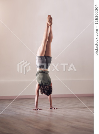Woman, handstand and yoga exercise in fitness studio of sports, workout and wellness for health. Back of person, pilates or upside down for balance, agility and strong core for power with flexibility 116303304
