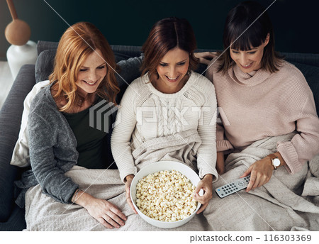 Top view, women and popcorn on sofa with friends for weekend, relax and happiness in home. TV, happy and remote with group in living room for movies, streaming and smile together with snack on couch Top view, women and popcorn on sofa with friends for weekend, relax and happiness in home. TV, happy and remote with group in living room for movies, streaming and smile together with snack on couch 116303369