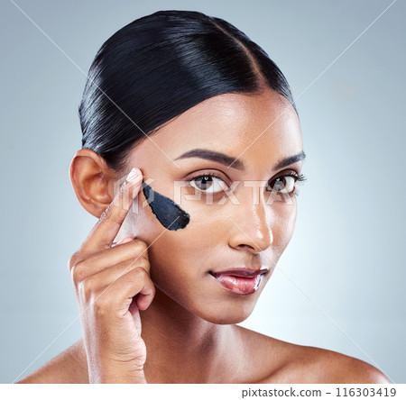 Charcoal, skincare or portrait of woman with face mask application in studio for dermatology, repair and acne treatment on grey background. Beauty, detox or model with facial product for glowing skin 116303419