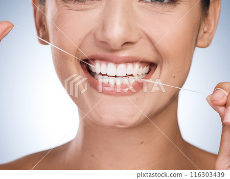 Woman, mouth and floss teeth in studio, orthodontics and cosmetics for smile on blue background. Female person, dental health and string for grooming, cleaning and self care or thread for plaque 116303439