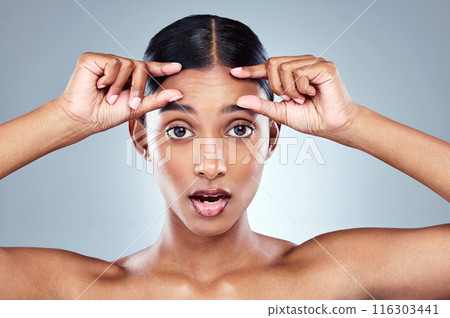 Portrait, woman and hands on forehead in studio for skin care, wellness and shock emoji. Eyes, filler and surprise for dermatology by grey background with cosmetics, collagen and detox with facial Portrait, woman and hands on forehead in studio for skin care, wellness and shock emoji. Eyes, filler and surprise for dermatology by grey background with cosmetics, collagen and detox with facial 116303441